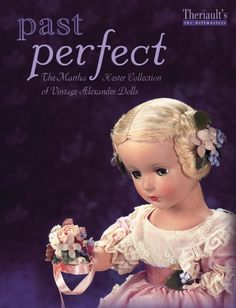 the doll is wearing a pink dress with flowers in her hair and holding a flower