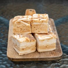 four pieces of cake sitting on top of a wooden cutting board