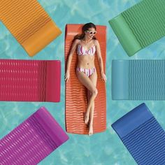 a woman laying on an inflatable mattress next to swimming pool with different colors