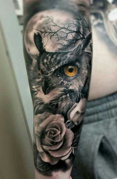 an owl with yellow eyes and roses on his arm is shown in black and white