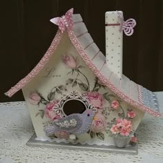 a decorative birdhouse with pink flowers on it