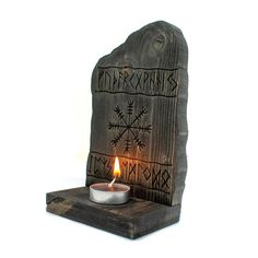 a candle is lit in front of a carved stone