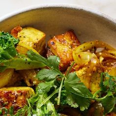 a bowl filled with cooked vegetables and herbs