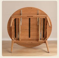 a round wooden table with two doors on each side and four knives in the middle