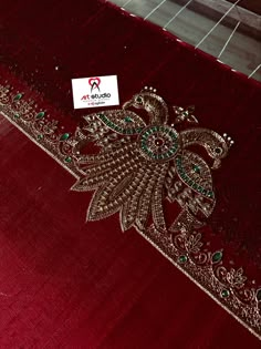 a red table cloth with an intricate design on the edge and a white sticker