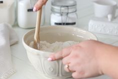 a person is stirring rice in a bowl with a wooden spoon and napkins on the counter