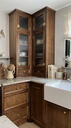 a kitchen with wooden cabinets and marble counter tops