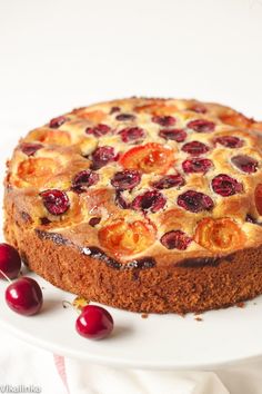 a cake with cherries is on a white plate