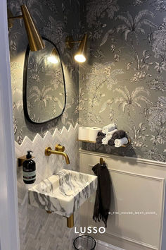 a bathroom with a marble sink and gold faucet