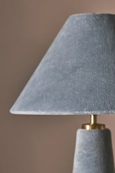 a lamp that is on top of a white table cloth with a gold trim around the base