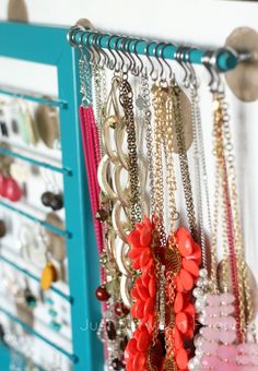 a rack filled with lots of different colored necklaces