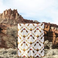 a quilt hanging from a clothes line in the desert