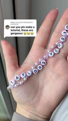 a person holding a beaded bracelet with letters on it