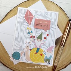 a close up of a greeting card on a table with a pen and paper crafting supplies