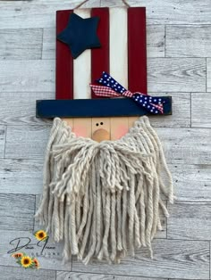 a wooden sign with a patriotic decoration on it's face and fringed hair