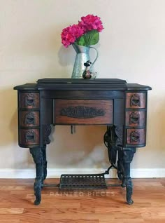 an antique desk with flowers in a vase sitting on it's top and bottom