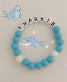 a beaded bracelet with a shark on it and the word sharkie written in white letters