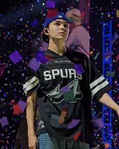 a young man standing in front of confetti