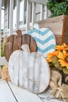 some pumpkins and sunflowers are sitting on a porch with other fall decorations