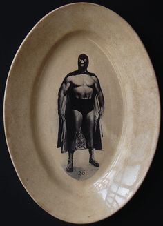 a white plate with a drawing of a man wearing a cape on it's side