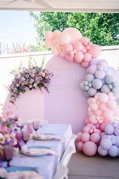 a table set up with balloons and flowers