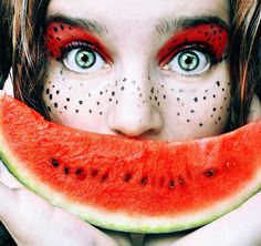 a woman with painted face and watermelon slice