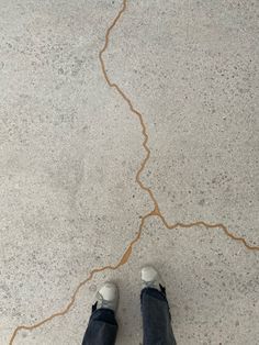 a person standing on the sidewalk with their feet crossed