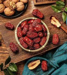 a bowl filled with raisins sitting on top of a wooden cutting board next to nuts