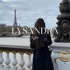 a woman is looking at the eiffel tower in paris, with the words lysandra light above her