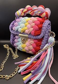 multicolored braided purse with chain on black background