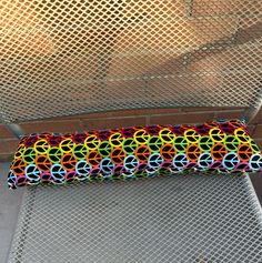 a colorful pillow sitting on top of a metal bench