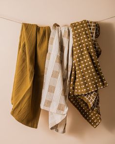 three scarves hanging on a clothes line with one folded and the other untied