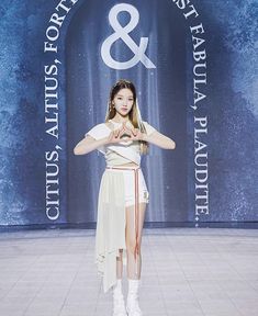 a woman standing in front of a blue and white sign