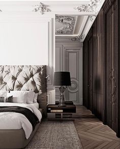 a bedroom with a bed, nightstands and lamps on either side of the bed