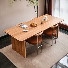 a wooden table with chairs around it in front of a window and a rug on the floor