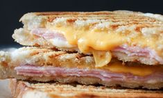 a grilled ham and cheese sandwich is stacked on top of each other with melted cheese