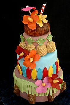 a colorful cake with pineapples and flowers on top