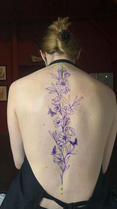 the back of a woman's body with flowers painted on her upper and lower back