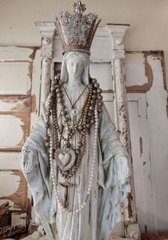 a statue with a crown on top of it's head and beads around its neck