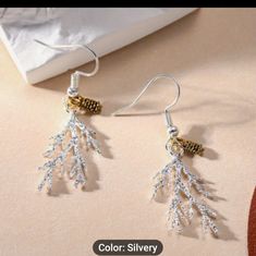 a pair of earrings with white beads hanging from it's earwires on top of a table