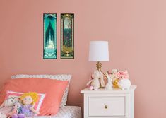 two pictures hang on the wall above a small white bed with pink sheets and pillows