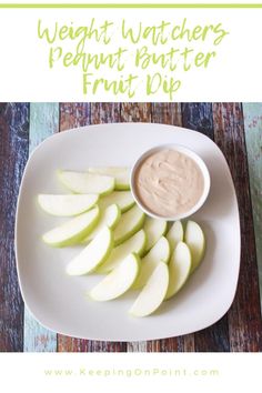 a white plate topped with sliced apples and dip