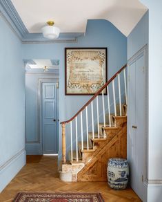 a hallway with blue walls and wooden stairs