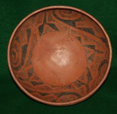 a brown bowl sitting on top of a green table