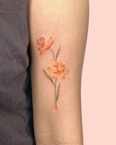 an orange flower tattoo on the left arm