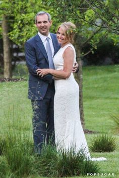 a man and woman are standing in the grass