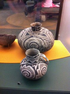 three vases sitting on top of a table next to each other