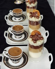 there are cups and saucers with desserts on them