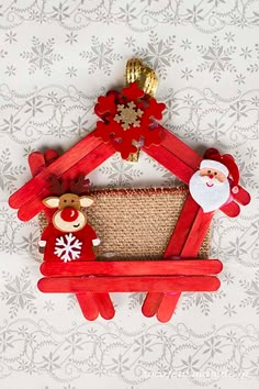 an ornament made out of popsicle sticks with santa and reindeer on it