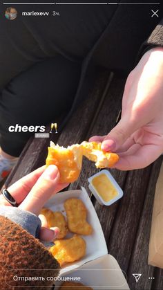 two people are eating some food on a picnic table with mustard and ketchup